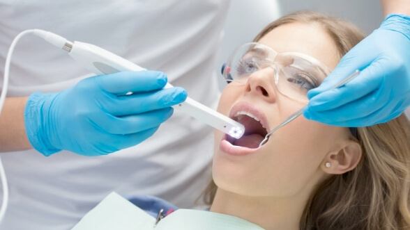 Dentist screening a patient with a cavity detection system