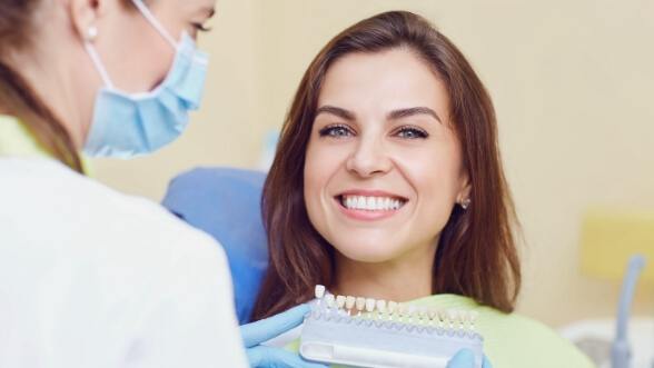 Woman in dental chair smiling after restorative dentistry in Mississauga