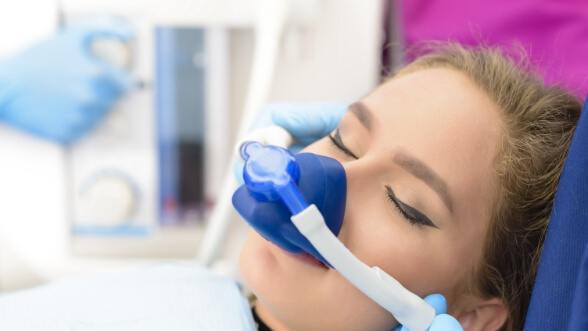 Woman with eyes closed and wearing mask for nitrous oxide sedation dentistry