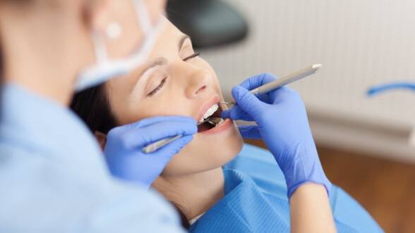 Dental patient with eyes closed receiving a dental exam
